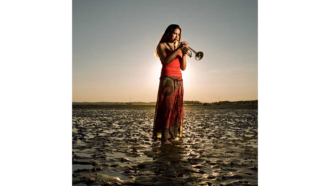 Portrait de Marie, élève au Conservatoire de Bordeaux, jouant de la trompette sur une plage déserte au crépuscule. © Richard Nourry